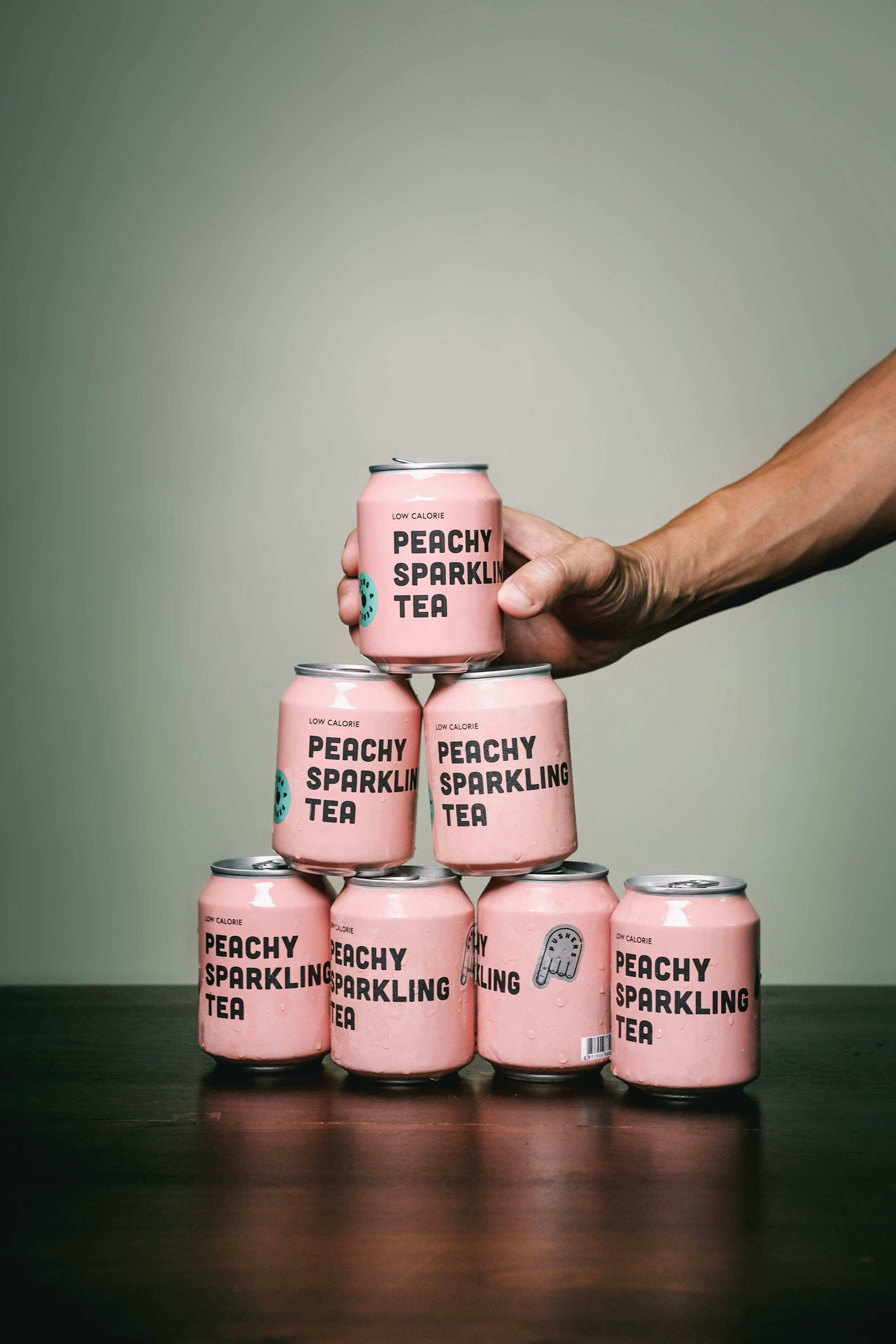 person holding pink and white labeled bottle